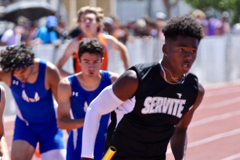 Servite's Max Thomas takes the baton for the final leg of the 1,600-meter relay.