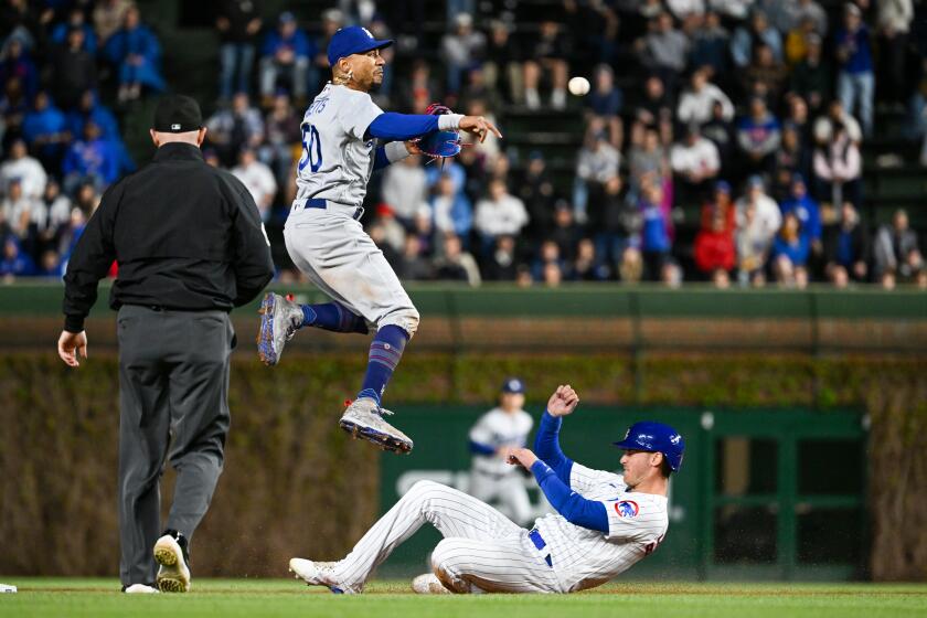 CHICAGO, ILLINOIS - APRIL 20: Mookie Betts #50 of the Los Angeles Dodgers turns a double play in the eighth inning against Cody Bellinger #24 of the Chicago Cubs at Wrigley Field on April 20, 2023 in Chicago, Illinois. (Photo by Quinn Harris/Getty Images)