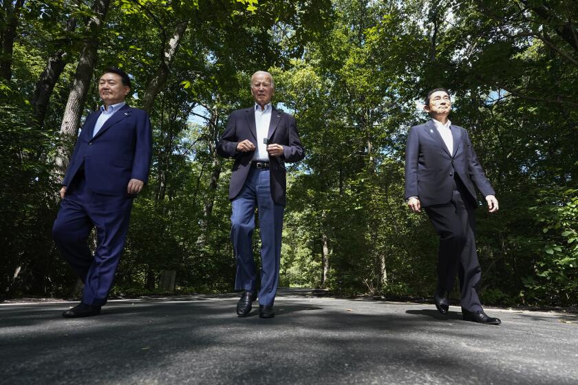 President Joe Biden, center, arrives to a joint news conference with South Korean President Yoon Suk Yeol, left, and Japanese Prime Minister Fumio Kishida Friday, Aug. 18, 2023, at Camp David, the presidential retreat, near Thurmont, Md. (AP Photo/Alex Brandon)