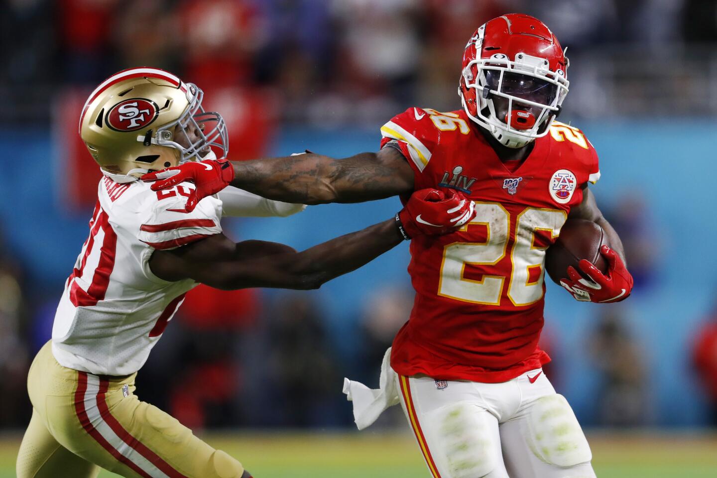 Kansas City Chiefs running back Damien Williams gives a stiff arm to San Francisco 49ers cornerback Jimmie Ward during the fourth quarter of Super Bowl LIV.