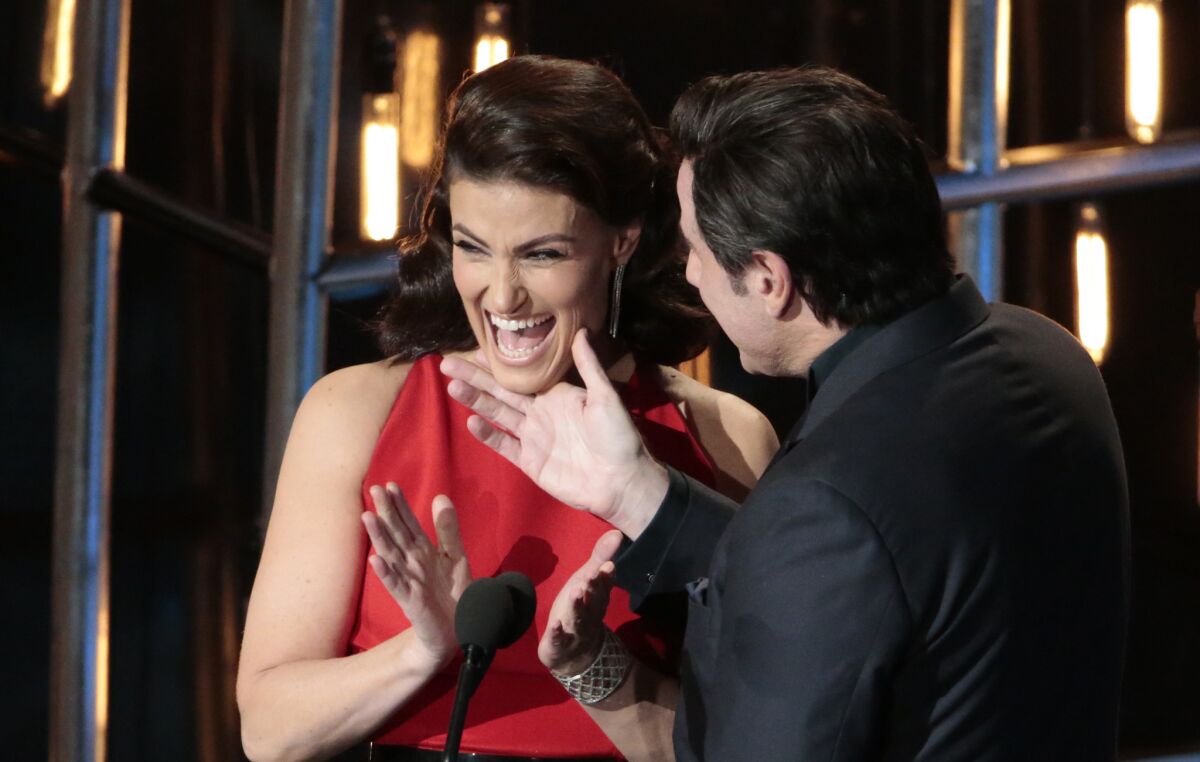 Idina Menzel and John Travolta in the midst of the chin-grabbing during Sunday's 87th Academy Awards at the Dolby Theatre.