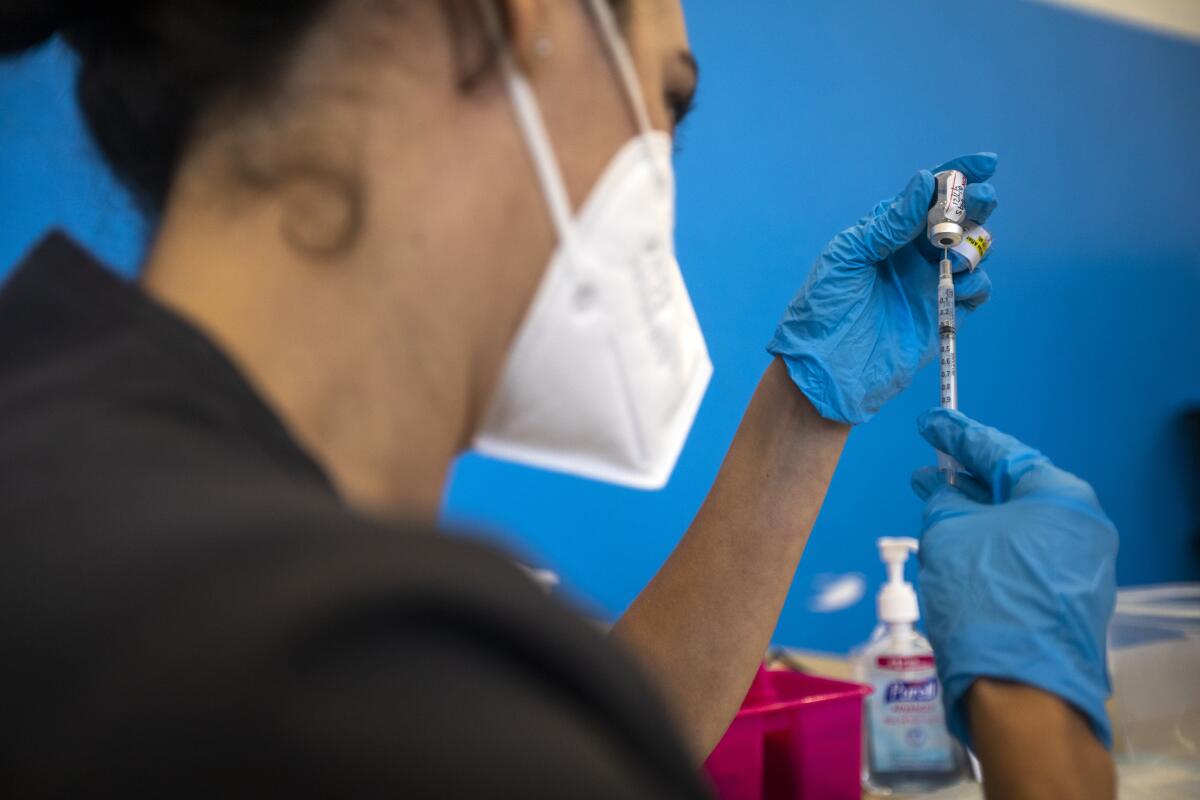 A nurse draws a vaccine into a syringe 