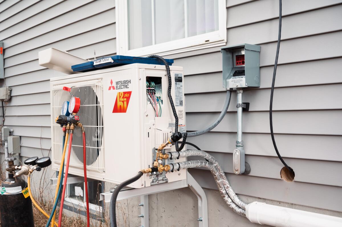 An electric heat pump attached to a house