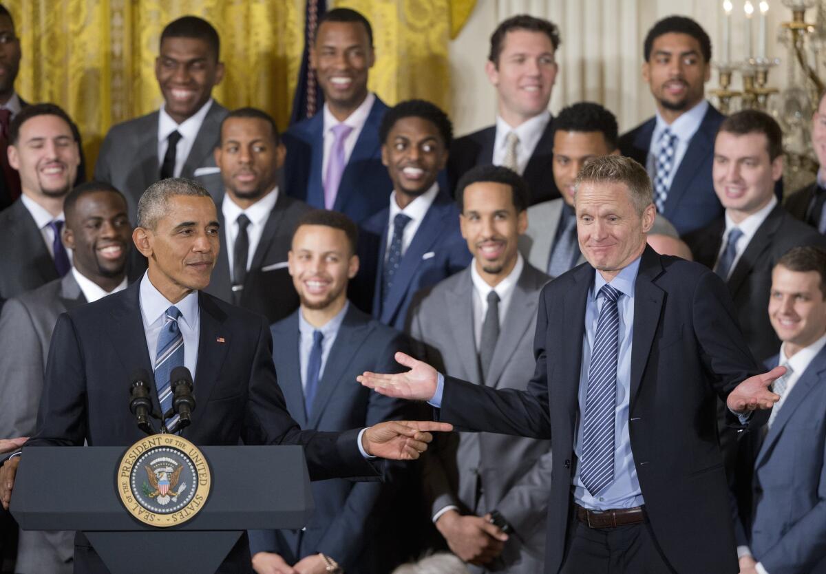 President Barack Obama points to Golden State Warriors head basketball coach Steve Kerr during a ceremony at the White House.