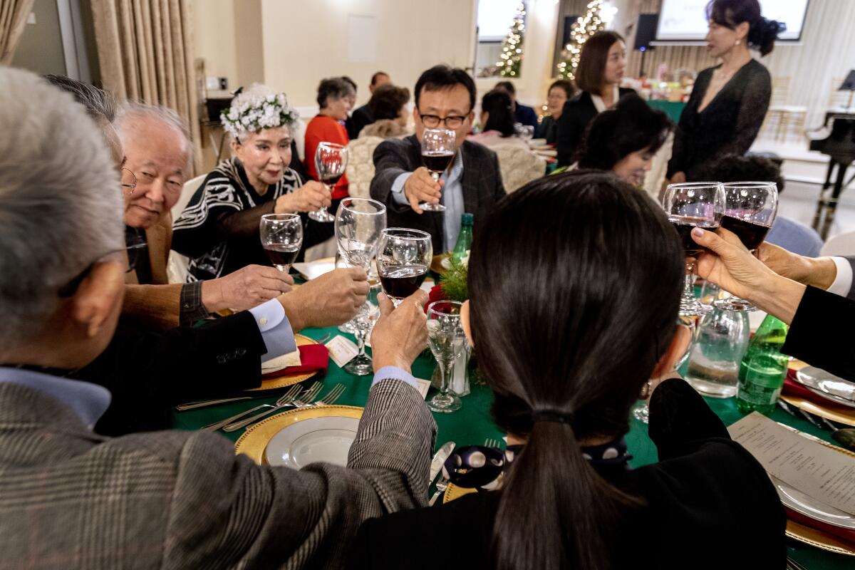 Former classmates and others toast each other during their end-of-year alumni gathering.