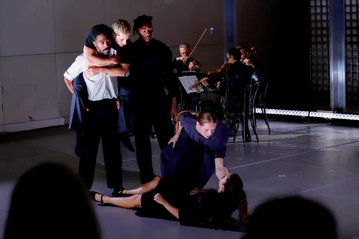 LA Dance Project company dancer performing onstage with seated musicians in background