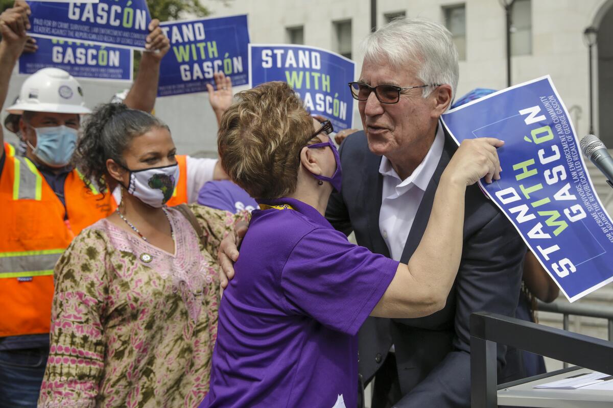 A supporter embraces Los Angeles District Attorney George Gascón 