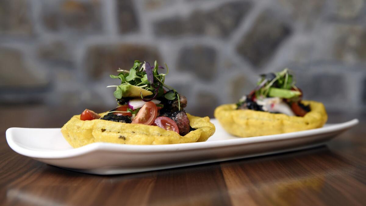 The salbutes with pavo en recado negro are piled with braised turkey and blackened chile sauce