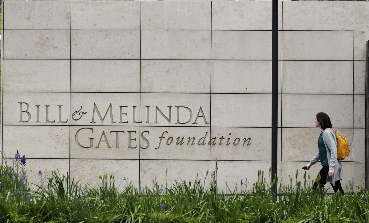 FILE - In this April 27, 2018, file photo, a person walks by the headquarters of the Bill and Melinda Gates Foundation in Seattle. As the Bill & Melinda Gates Foundation works to expand its governance, it announced Thursday, Aug. 18, 2022, that it has added two trustees to its board. (AP Photo/Ted S. Warren, File)