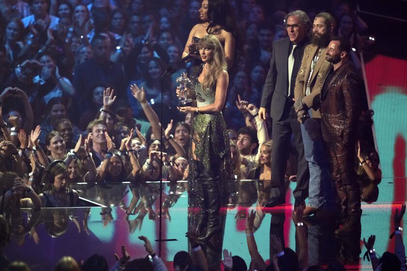 Taylor Swift, centro, y Post Malone, tercero de izquierda derecha tras Swift, reciben el premio al video del a?o por "Fortnight" durante los Premios MTV a los Videos Musicales el miércoles 11 de septiembre de 2024 en la Arena UBS en Elmont, Nueva York. La presentadora Megan Thee Stallion, desde el extremo izquierdo, el cinefotógrafo Rodrigo Prieto y Ethan Tobman miran.