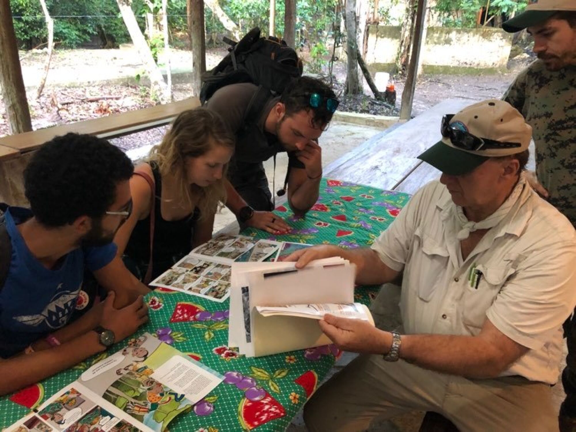 Un grupo de turistas escuchan a Richard Hansen en el campamento de El Mirador.