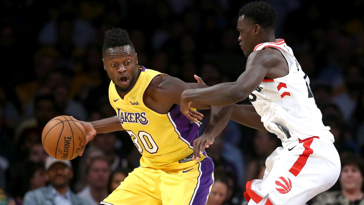 Lakes forward Julius Randle tries to drive past Raptors forward Pascal Siakam during their game Friday night.