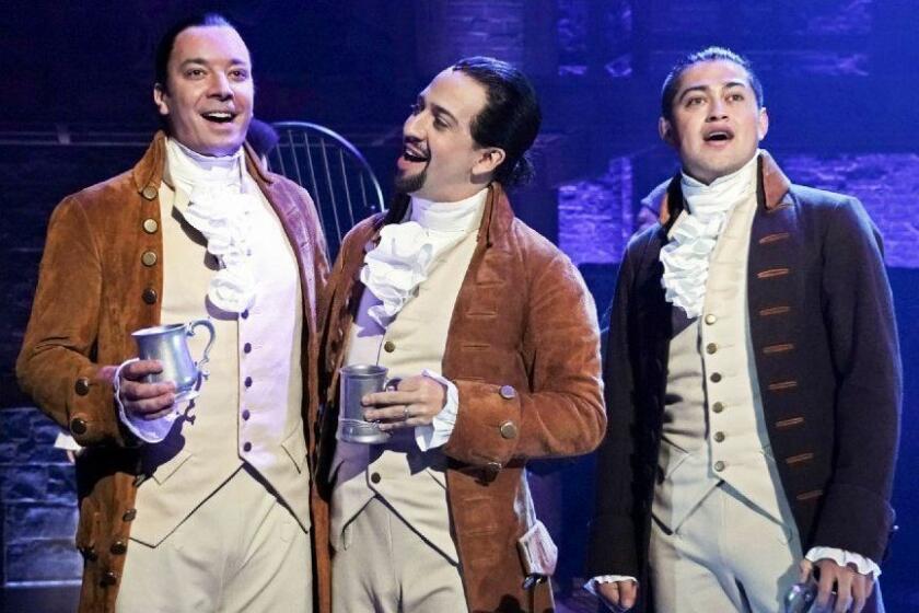 This image released by NBC shows Jimmy Fallon, host of "The Tonight Show Starring Jimmy Fallon," left, with Lin-Manuel Miranda, center, and a member of the cast from the musical "Hamilton," at the Luis A. Ferré Performing Arts Center in San Juan, Puerto Rico. Fallon will join the cast in a performance of "The Story of Tonight” from the Tony-winning musical which will air on Fallon's show on Tuesday, Jan. 15. (Andrew Lipovsky/NBC via AP)