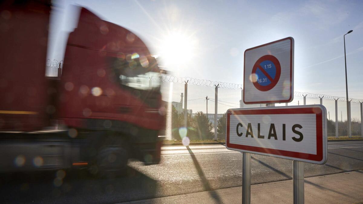 A truck passes the road sign on the outskirts of the port of Calais.