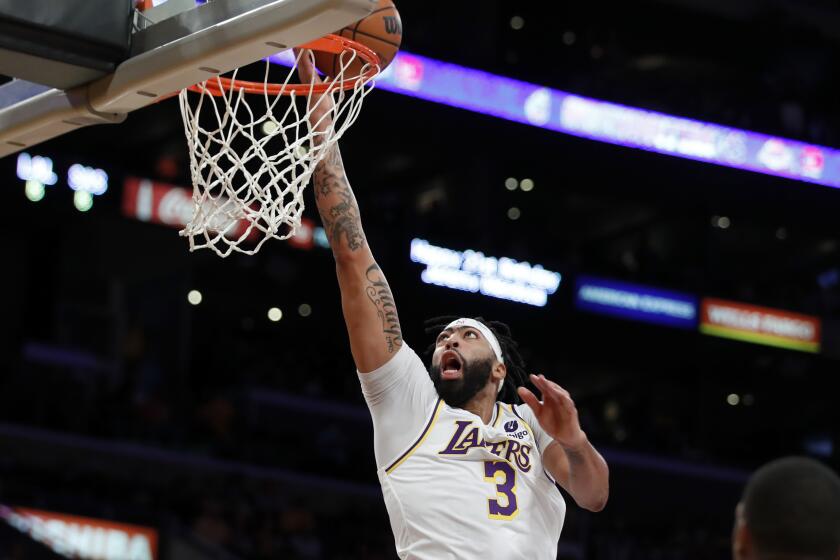 Los Angeles Lakers forward Anthony Davis lays up a shot against the San Antonio Spurs during the first half of an NBA basketball game Sunday, Nov. 14, 2021 in Los Angeles. (AP Photo/Alex Gallardo)