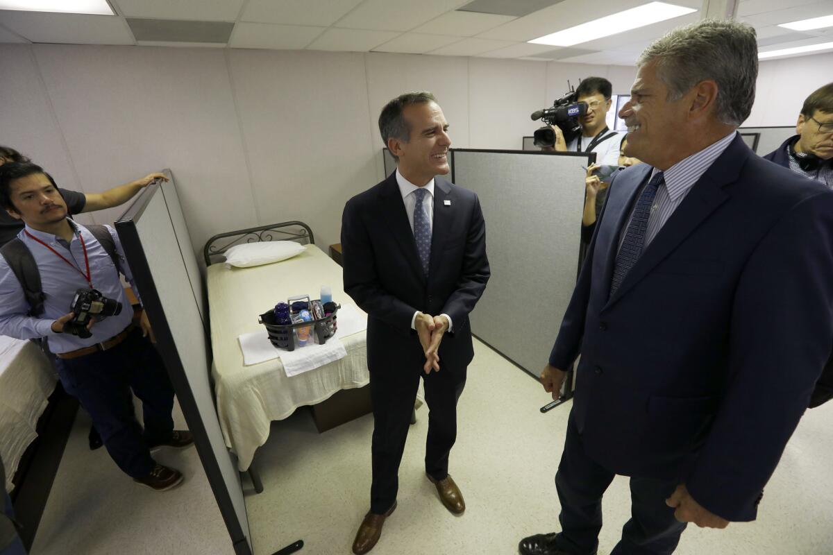 Mayor Eric Garcetti, left, and shelter operator John Maceri tour the the sleeping area of the temporary homeless shelter in downtown L.A.