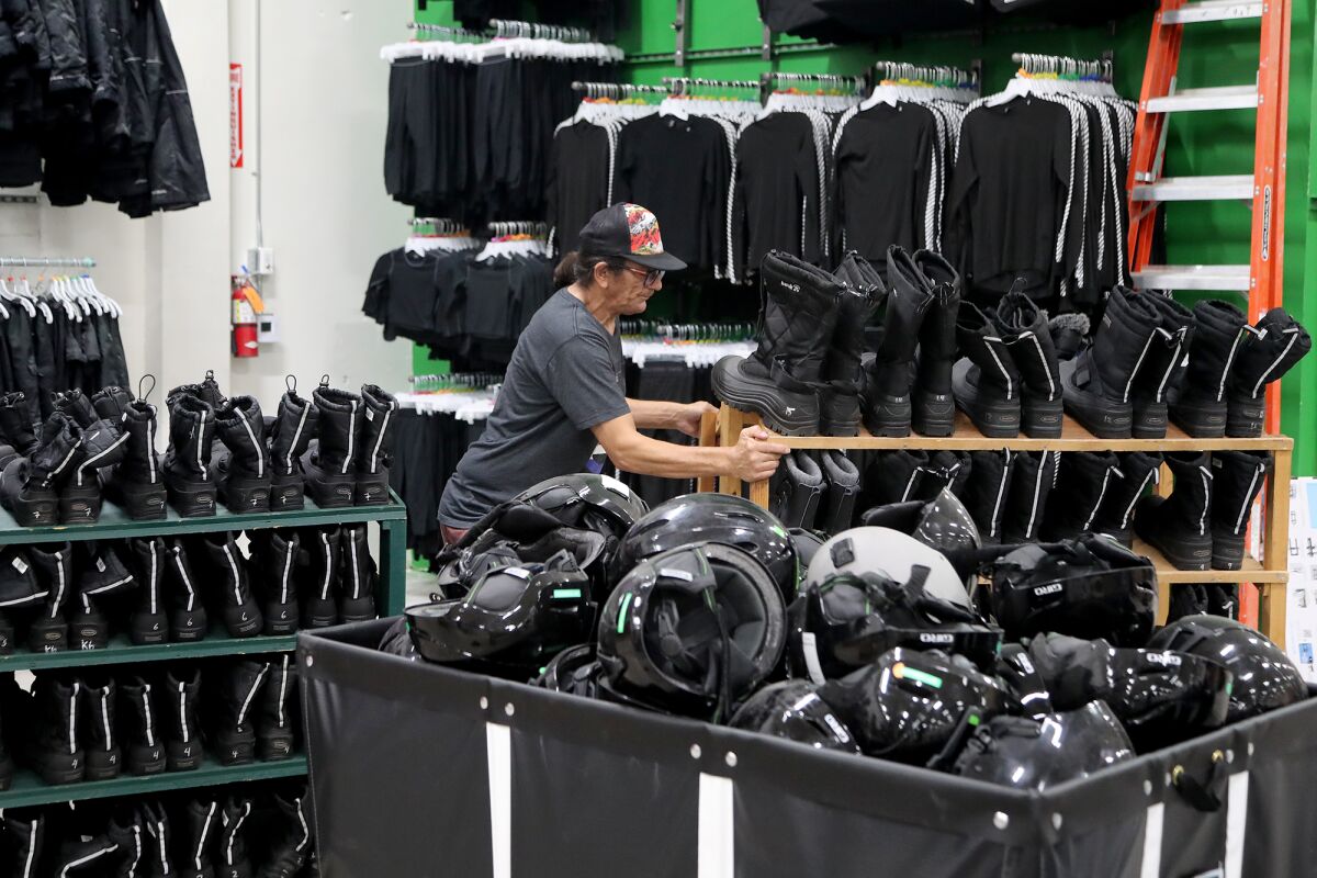 Employee Don Fisher moves a rack of rental snowshoes into the new Sports Basement in Fountain Valley on Wednesday.