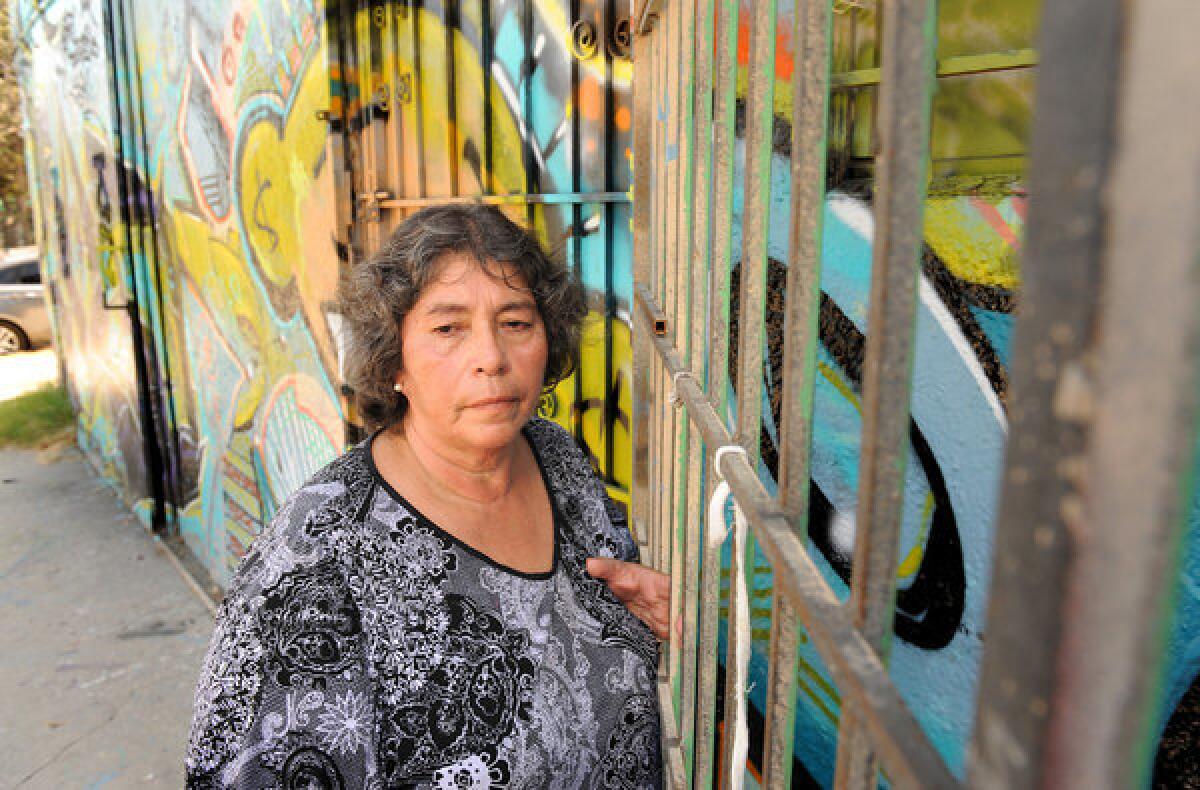 Francisca Pena stands outside the building on San Pedro Street where her husband was shot and killed in 1990. The suspected gunman was arrested Monday after the LAPD found DNA evidence.