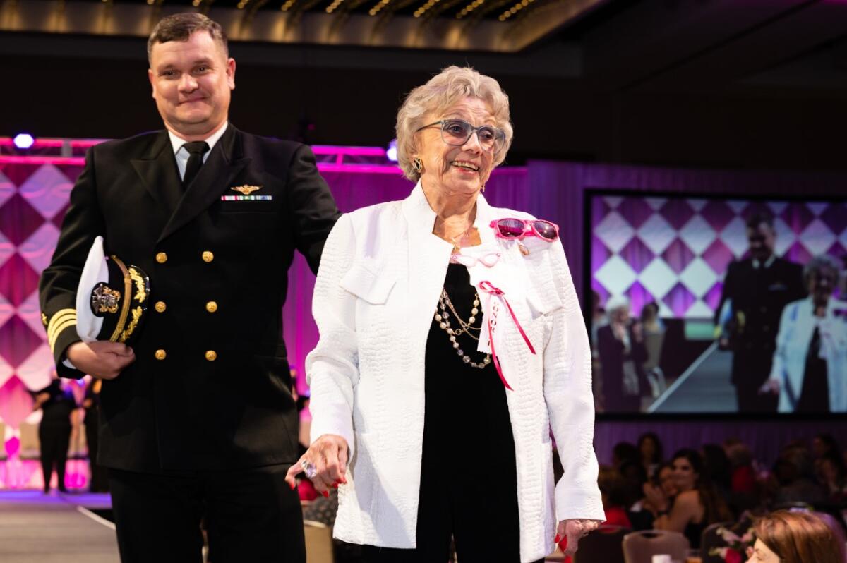 Roberta Tidmore walks down the Salvation Army's "Women of Distinction" runway with her grandson, Navy Cmdr. Bryce Kammeyer.