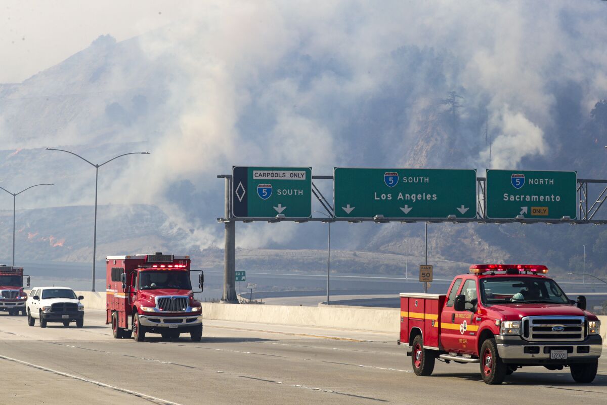 Smoke rises in the Newhall Pass during the Saddleridge fire.