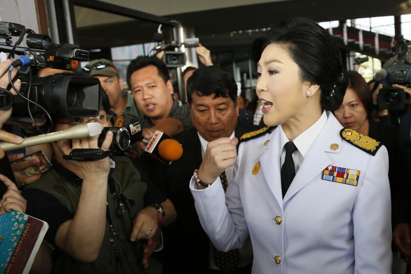 Thai Prime Minister Yingluck Shinawatra speaks to reporters as she leaves a meeting with election commissioners at the Army Club in Bangkok.