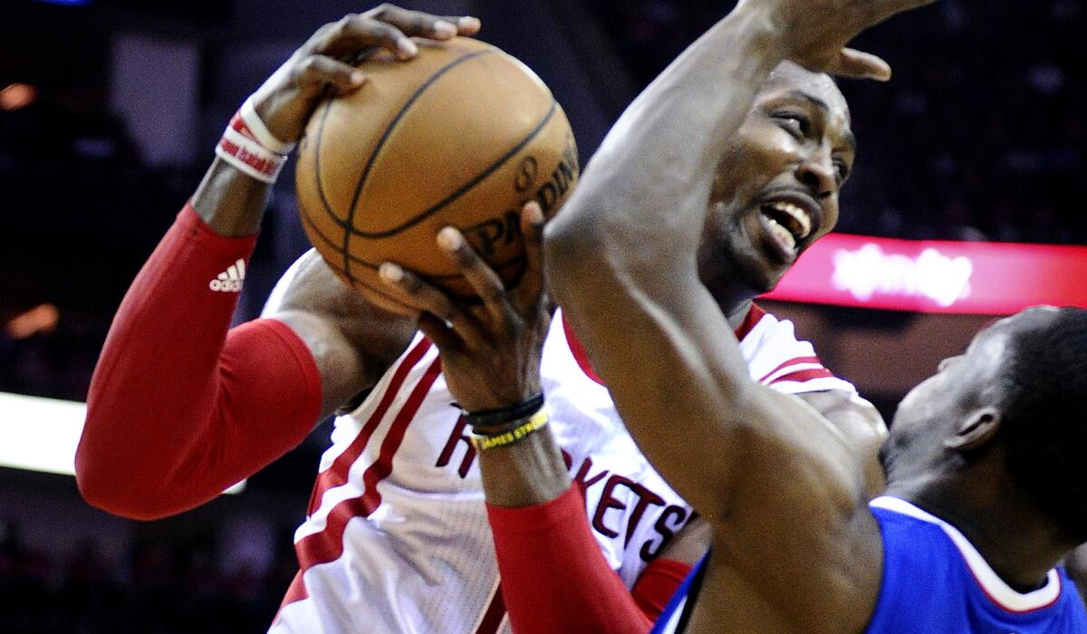 Rockets center Dwight Howard falls onto Clippers guard Lester Hudson after being fouled by L.A. center DeAndre Jordan (not pictured) in Game 2.