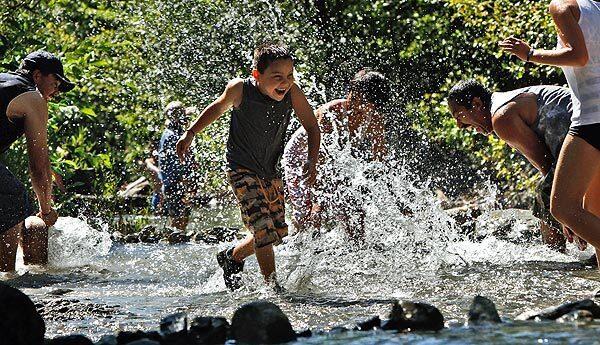 Amid sizzling heat Saturday, members of the Moreno and Vasquez families from Riverside frolic in the cold water of a Lytle Creek stream flowing through San Bernardino National Forest.