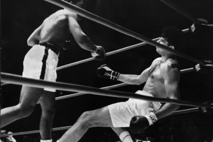 Cassius Clay, left, makes good his prediction by knocking out Alejandro Lavorante in the fifth round July 21, 1962.