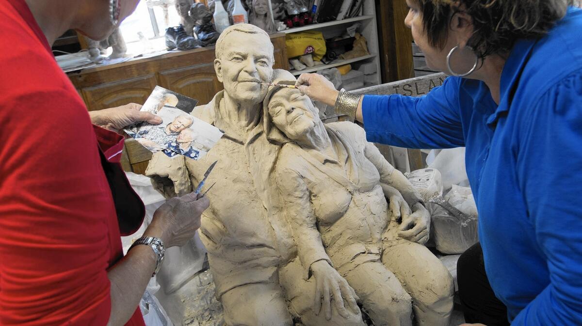 A sculpture in the works by Miriam Baker, left, and Rhonda Jones depicts Balboa Island couple Herman and Lois Dorkin as they sat on a bench on the island in 2003. The artwork is based on a smaller sculpture Baker made 13 years ago after she saw the couple on the bench along North Bayfront.