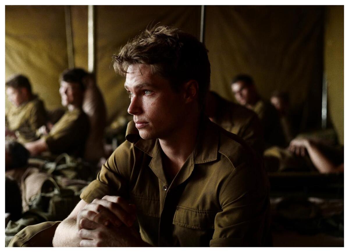 A young man shares a tent with fellow soldiers.