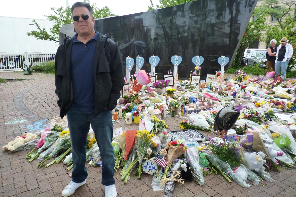 A man stands at a memorial for victims of the mass shooting in Highland Park, Ill.