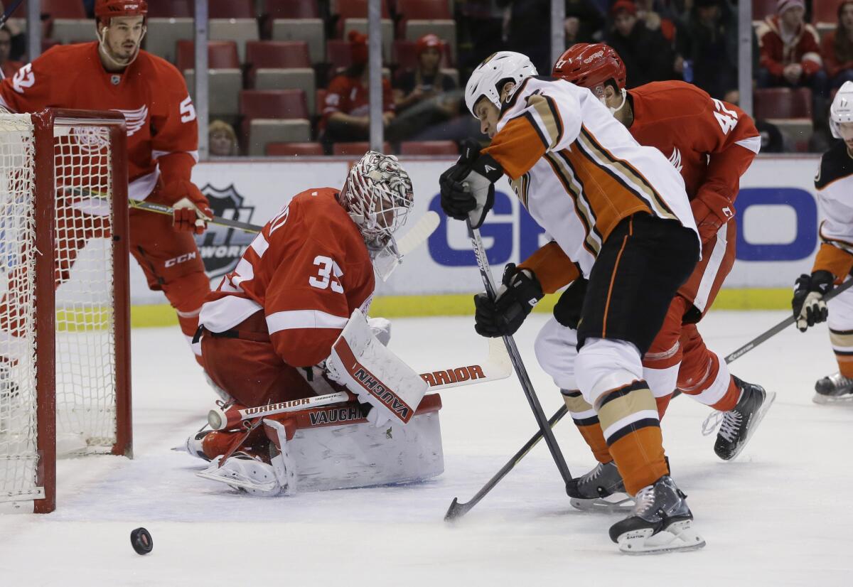 Red Wings goalie Jimmy Howard deflects a shot by Ducks defenseman Kevin Bieksa, right, during the first period of a game in Detroit on Jan. 23.