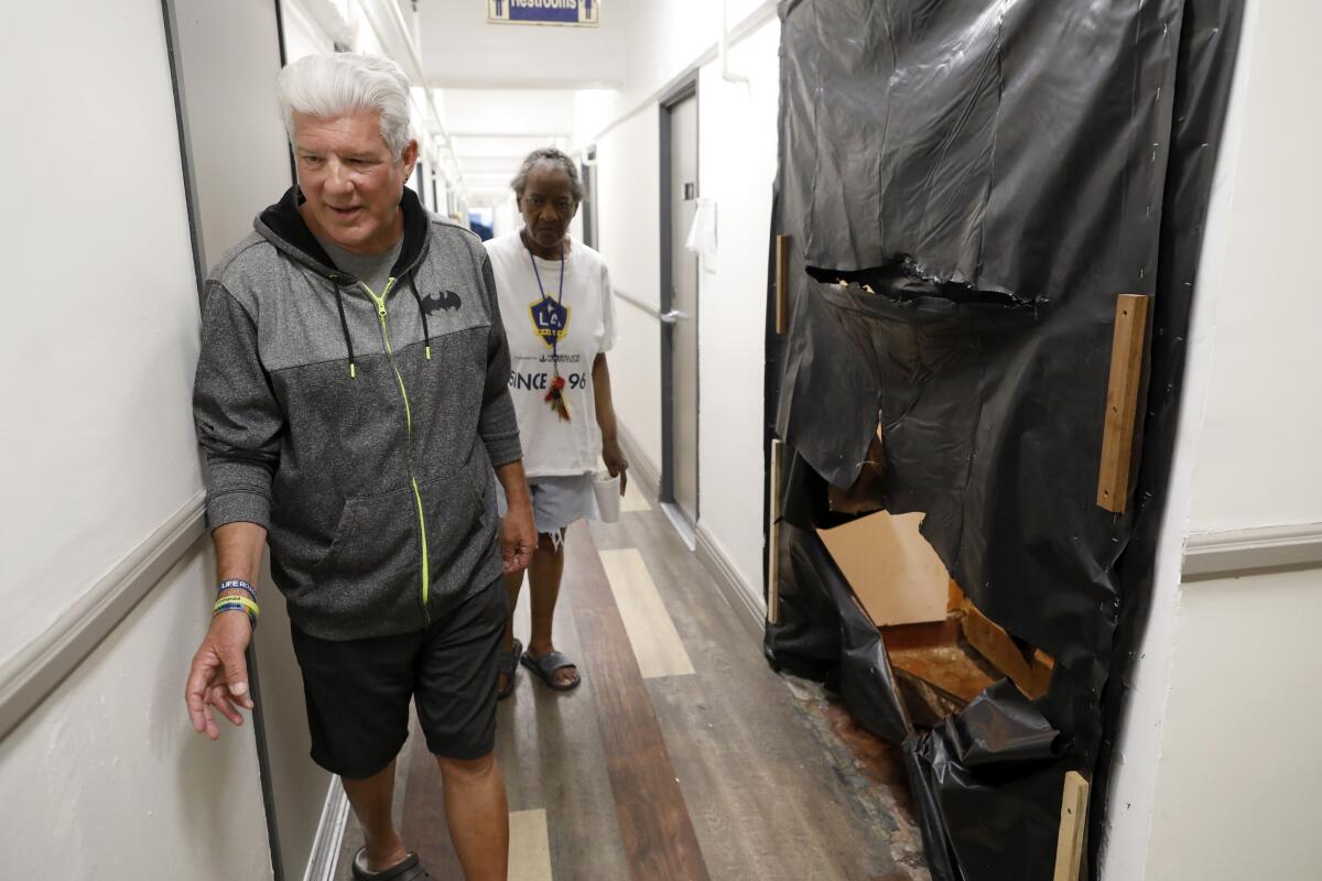 Anthony Thomas, 65, shows where communal shower stalls were removed at the Madison Hotel on skid row.