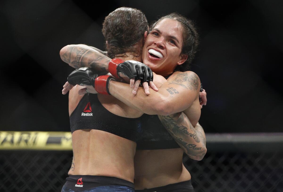 Amanda Nunes, right, embraces Germaine de Randamie after a mixed martial arts women's bantamweight championship bout at UFC 245, Saturday, Dec. 14, 2019, in Las Vegas. (AP Photo/John Locher)