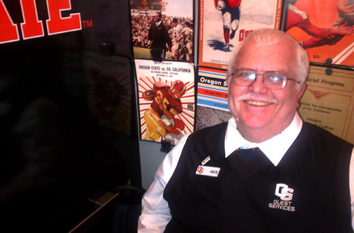 Rick Switzer has used old programs, including one prominently featuring the Trojans, for the decor of his workspace.