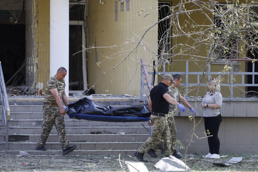 Police officers carry a dead body after a Russian strike in Kyiv, Ukraine, Thursday, June 1, 2023. Ukrainian officials say the latest pre-dawn Russian missile attack on Kyiv has killed at least three people, including a 9-year-old child and her mother. (AP Photo/Alex Babenko)