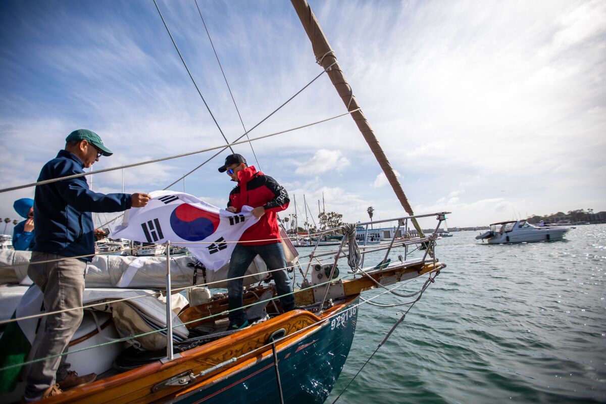 Two men carry the Korean flag on a yacht
