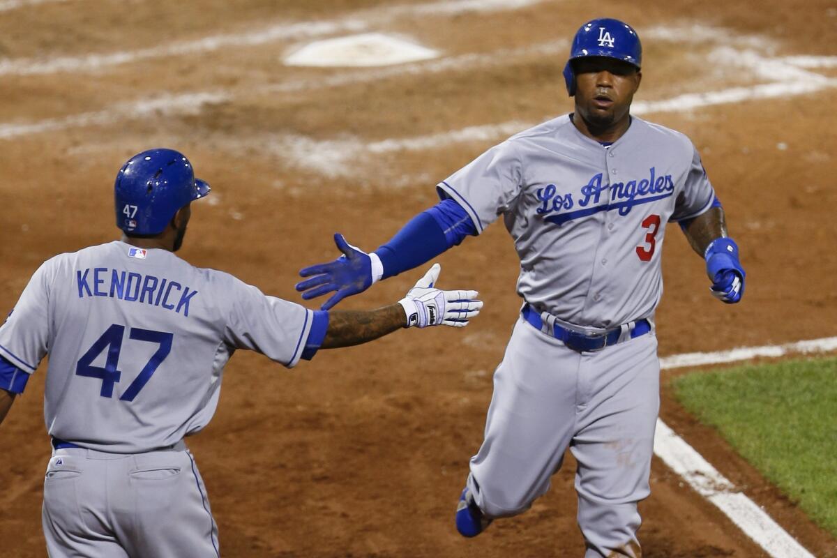 Dodgers' Carl Crawford, right is greeted by Howie Kendrick after scoring against Pittsburgh on Aug. 7.