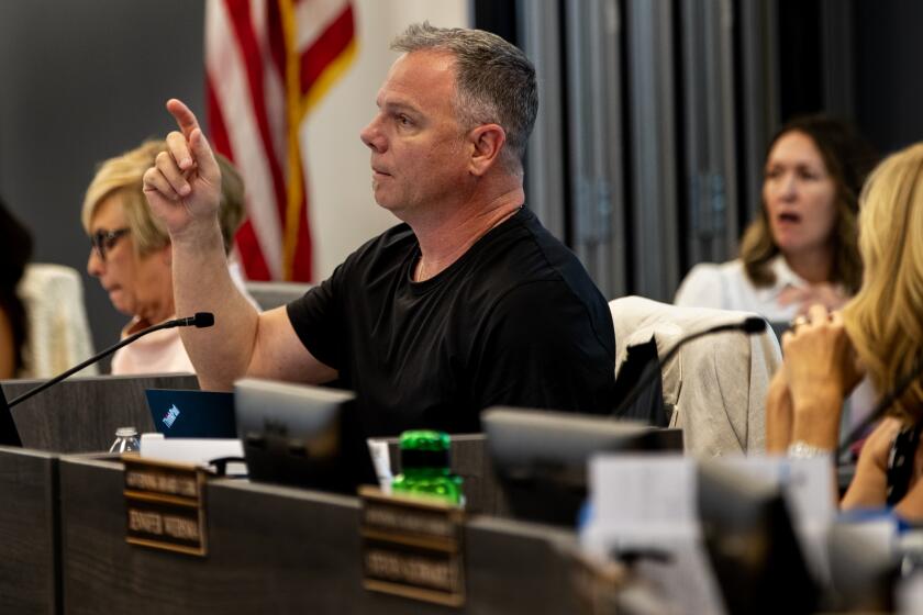 TEMECULA, CA - JULY 18, 2023: Temecula School Board President Joseph Komrosky points to teacher and parent Jennee Scharf to eject her from the meeting after she called Board member Danny Gonzalez a "homophobe" on July 18, 2023 in Temecula, California. Gonzalez had previously made unfounded derogatory remarks about Harvey Milk and LBGTQ issues in regards to curriculum.The conservative majority on the school board is at the center of a debate with Gov. Gavin Newsom who has threatened to fine the board over $1 million because of their resistance to include a lesson involving Harvey Milk.(Gina Ferazzi / Los Angeles Times)
