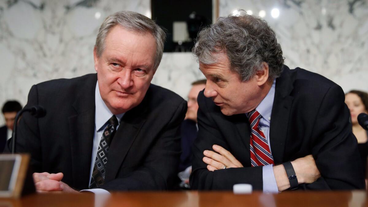 Sen. Mike Crapo (R-Idaho), left, chairman of the Senate Banking Committee, talks with Sen. Sherrod Brown (D-Ohio) before a hearing Nov. 28.