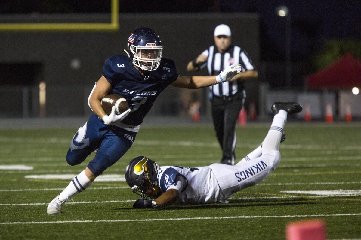 Justin McCoy of Newport Harbor runs the ball for a first down against Santa Monica in a nonleague game on Friday at Davidson Field.