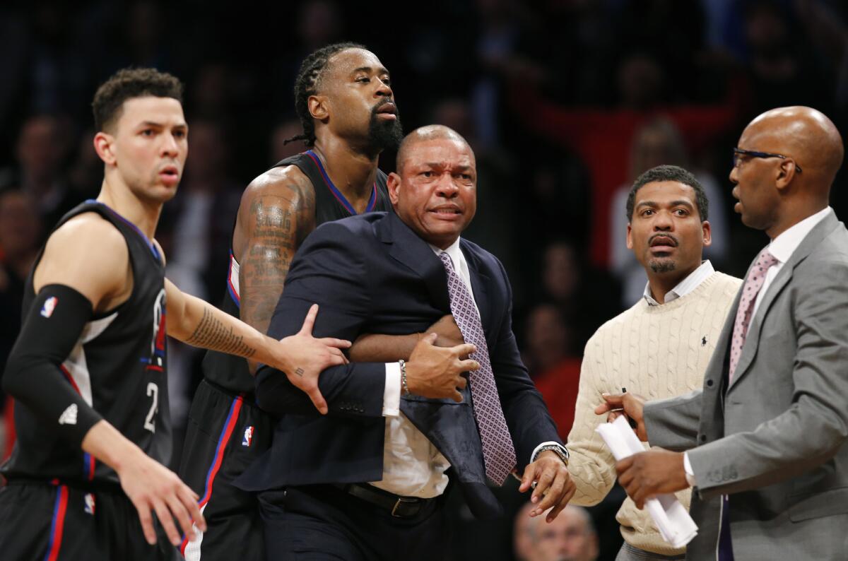 Clippers guard Austin Rivers, left, center DeAndre Jordan and others move to restrain Coach Doc Rivers during an argument about a referee's call Tuesday night against Brooklyn.