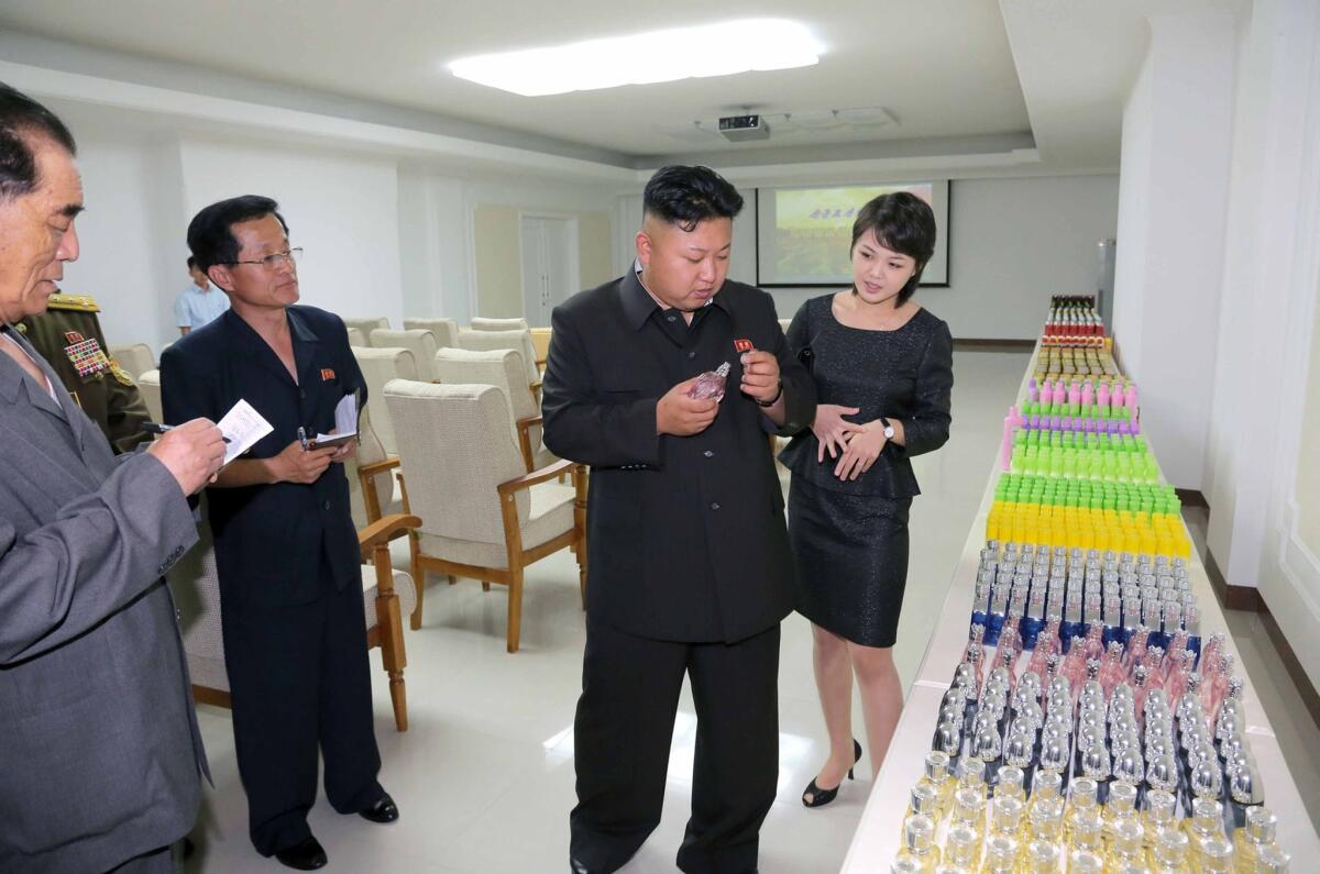 North Korea's official news agency released this undated image Thursday of leader Kim Jong Un, center, visiting the Taedonggang Combined Fruit Processing Factory in Pyongyang. With Kim is his wife, Ri Sol Ju.