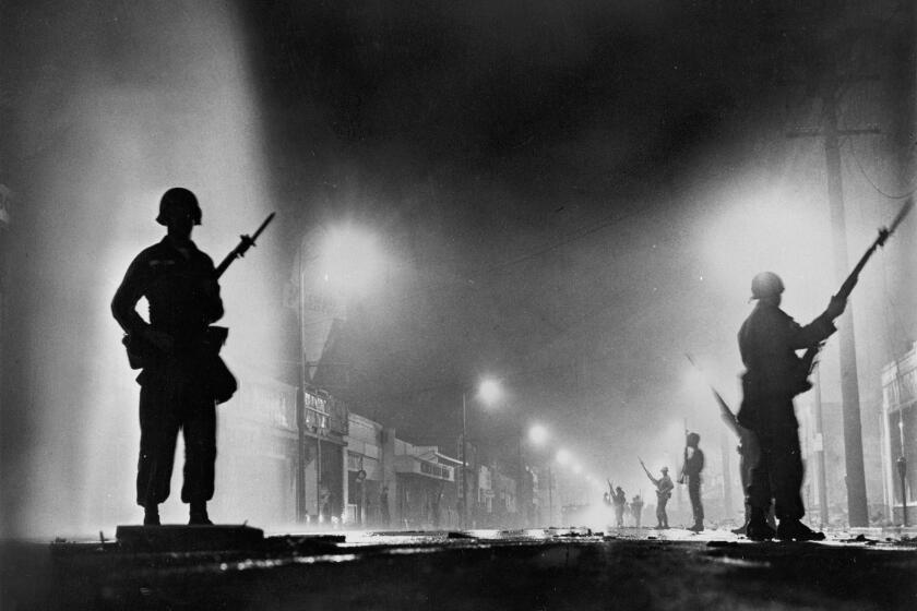 National Guard troops secure a stretch of 103rd Street, dubbed Charcoal Alley, in Watts to help L.A. authorities restore order on August 13, 1965. The riots, sparked by the arrest of a black motorist for drunk driving, lasted for six days.