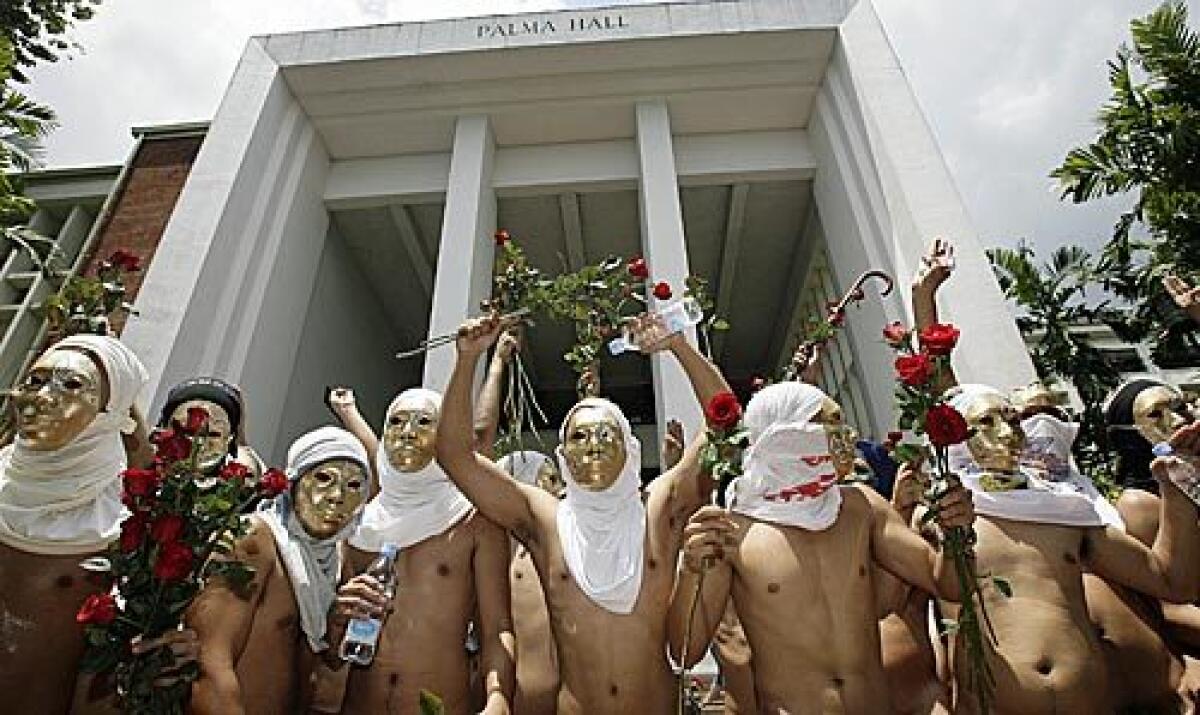 Members of the Alpha Phi Omega fraternity gesture as they run naked inside the campus to mark the 100th year anniversary of University of the Philippines in suburban Quezon City, north of Manila.