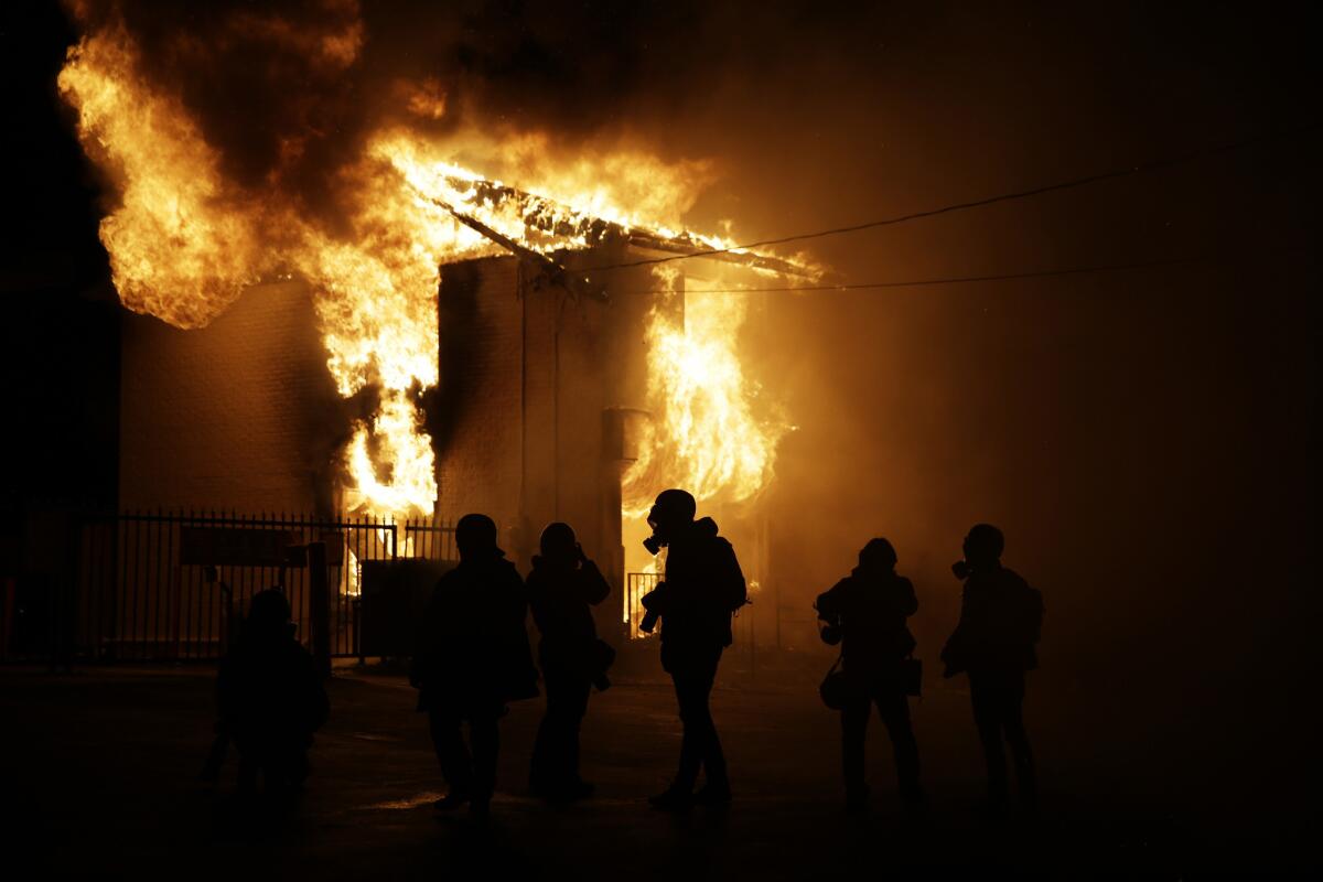 Members of the media arrive at the scene of a fire after the announcement of the grand jury decision Monday in Ferguson, Mo. A grand jury decided not to indict Ferguson police officer Darren Wilson in the death of Michael Brown, whose fatal shooting sparked sometimes violent protests.