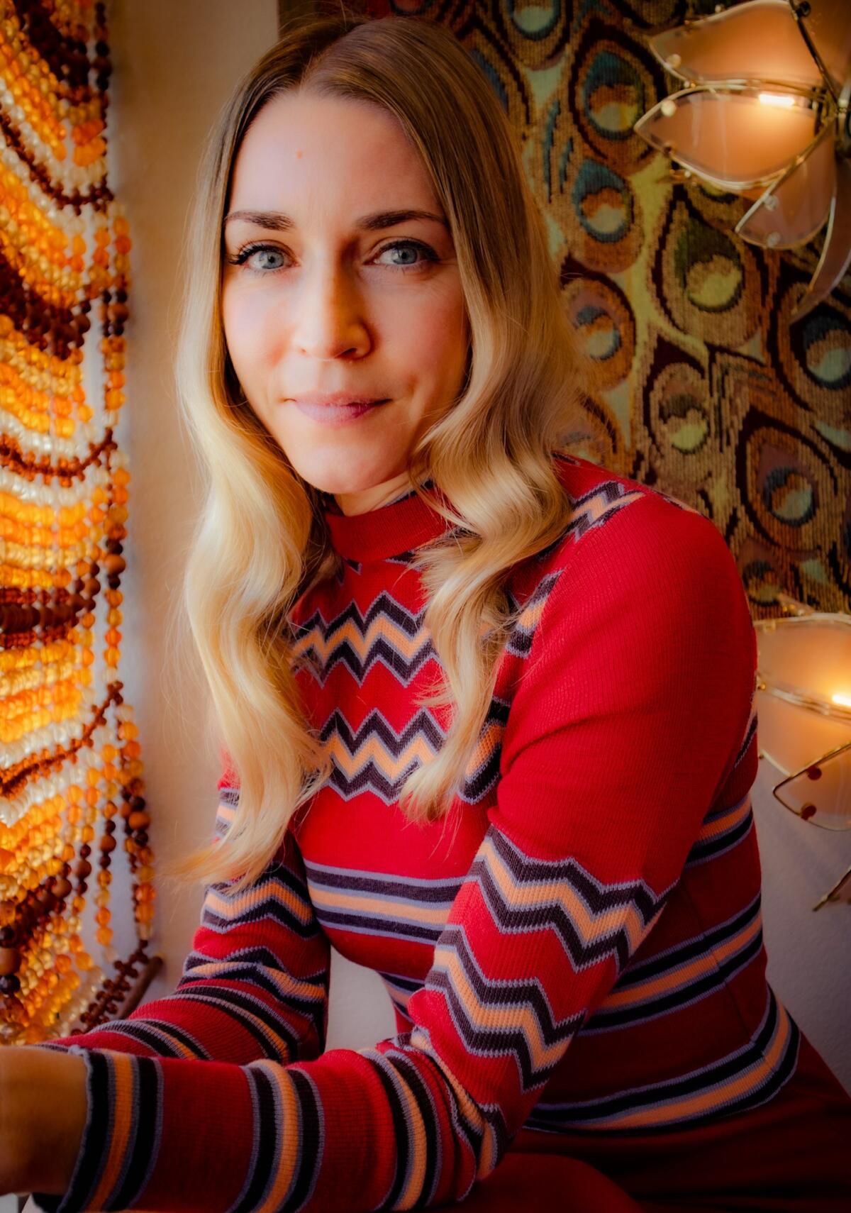 A woman with long blond hair in a red striped sweater