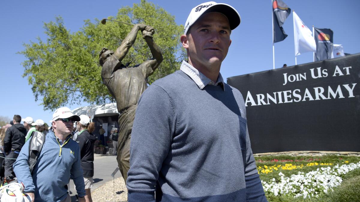 Sam Saunders walks past a bronze statue honoring his grandfather, Arnold Palmer, while heading to the first tee for the first round of the Arnold Palmer Invitational on Thursday.