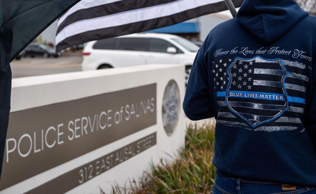 Lyle Skeen wears a blue lives matter hoodie outside the Salinas Police Department after a fatal shooting of an officer in the line of duty in Salinas, Calif., Saturday, Feb. 26, 2022. Salinas Police Department Officer Jorge David Alvarado pulled over a car about 10:45 p.m. on Friday in the area of Market Street and Griffin Street and the traffic stop turned into a shootout, said Miguel Cabrera, a spokesperson for the police department. (David Rodríguez Muñoz/The Californian via AP)