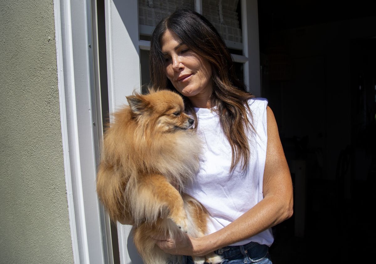 A woman holds her dog.